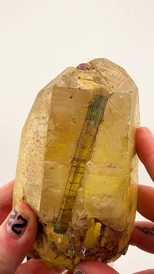 Golden crystal, emerald-green tourmaline, and millions of years of geological perfection.